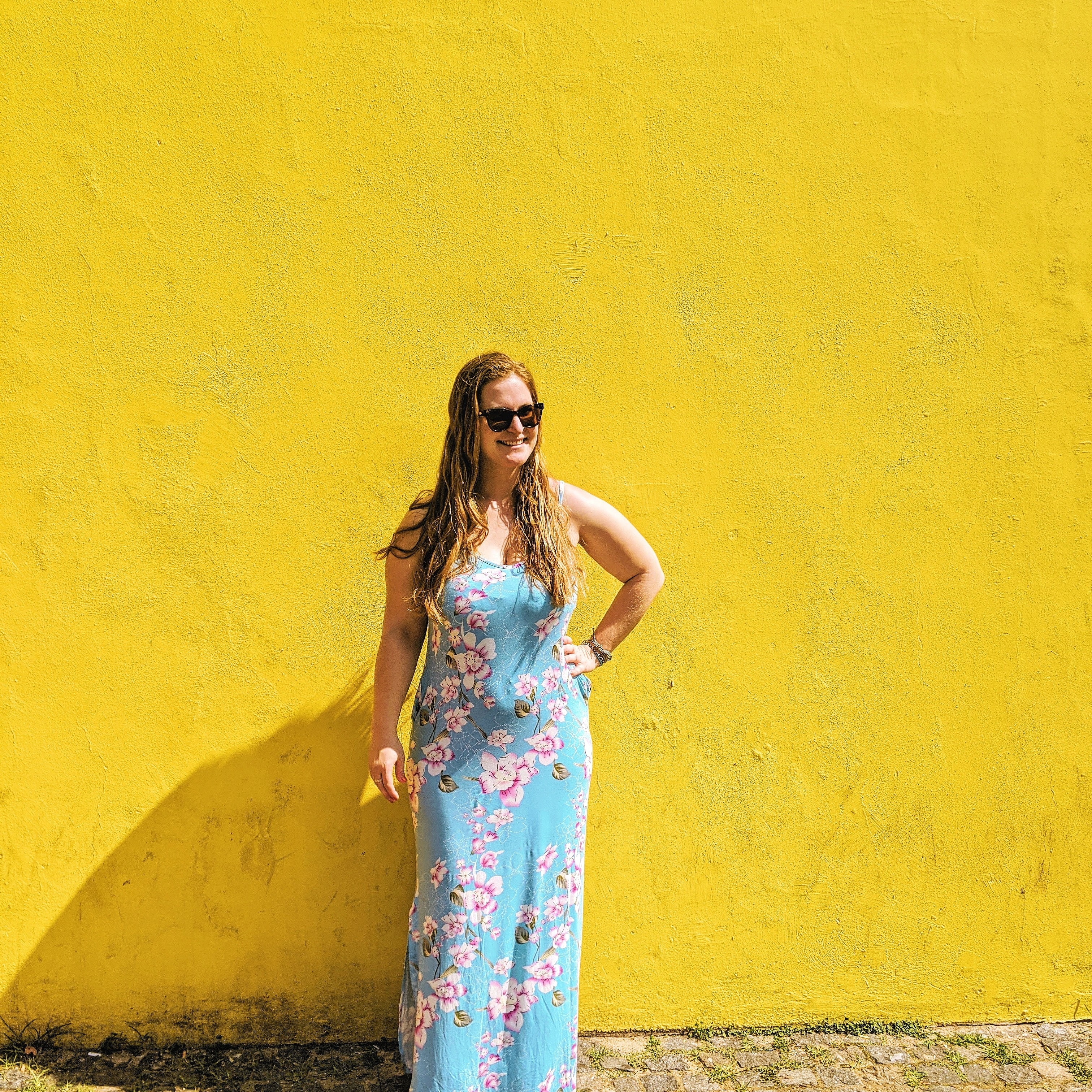 woman in blue dress on yellow wall